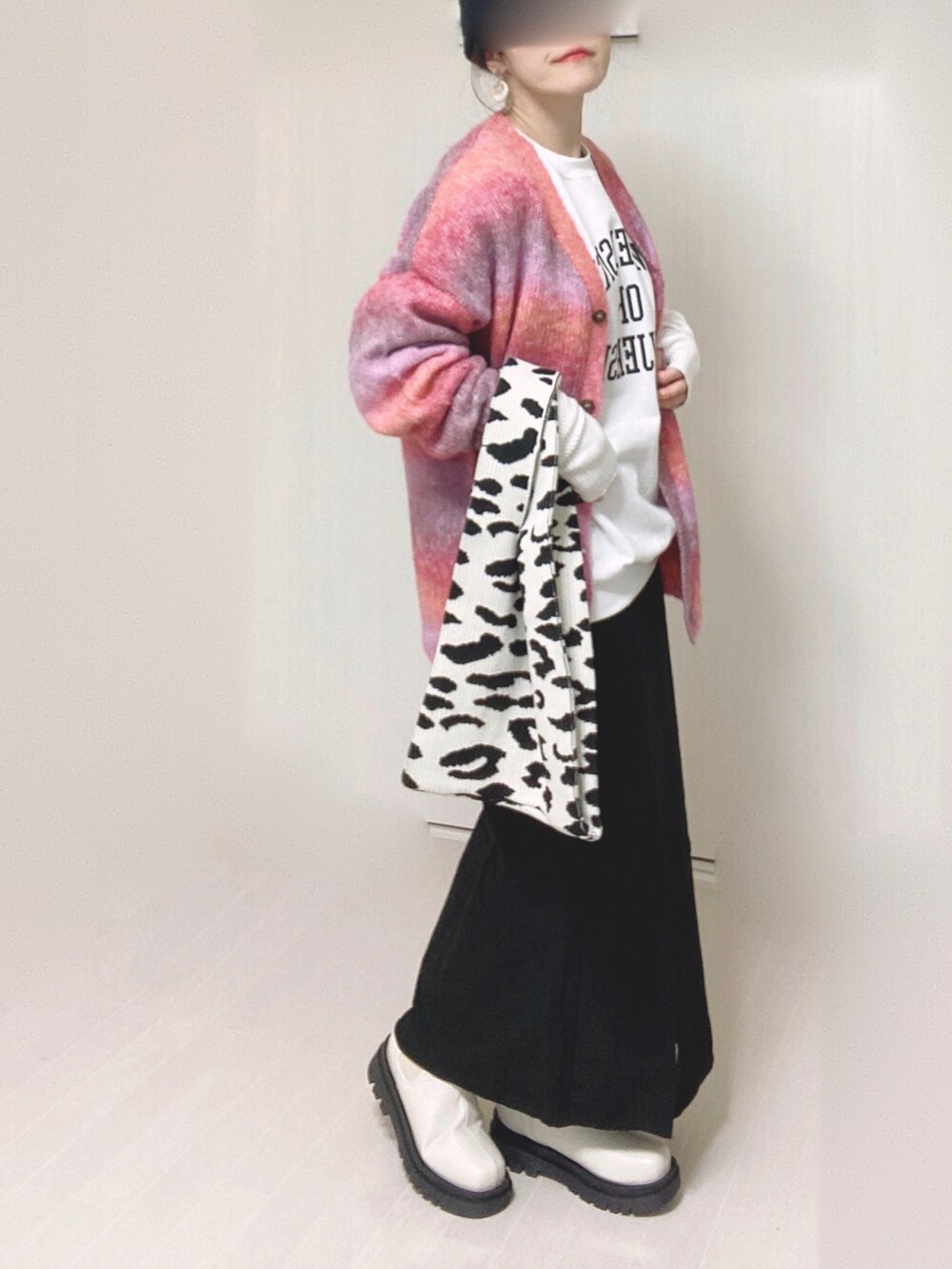 ブラック系のスカート、ホワイト系のスウェット、ピンク系のカーディガン/ボレロを着用したレディースの秋コーディネートの2枚目の写真