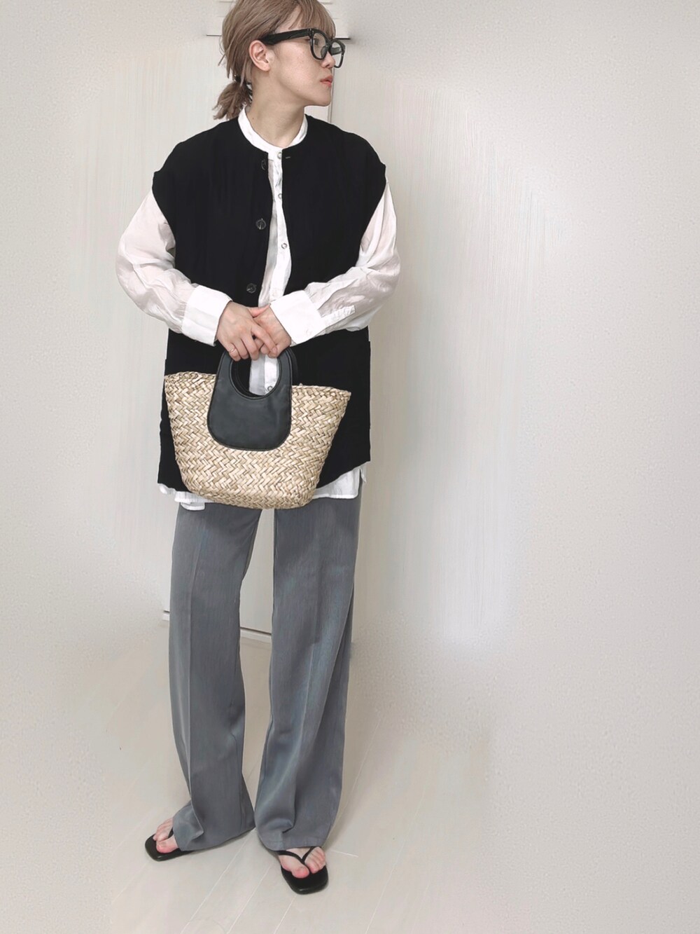 ブラック系のベスト、ホワイト系のシャツ/ブラウス、ブラック系のサンダルを着用したレディースの夏コーディネートの2枚目の写真