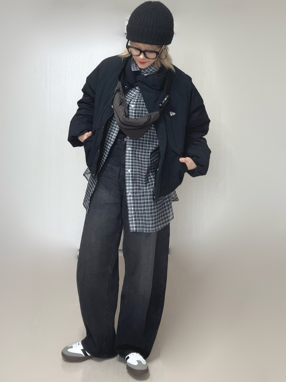 ブラック系のシャツ/ブラウス、ブラック系のニット/セーター、ブラック系のデニムパンツを着用したレディースの冬コーディネートの2枚目の写真