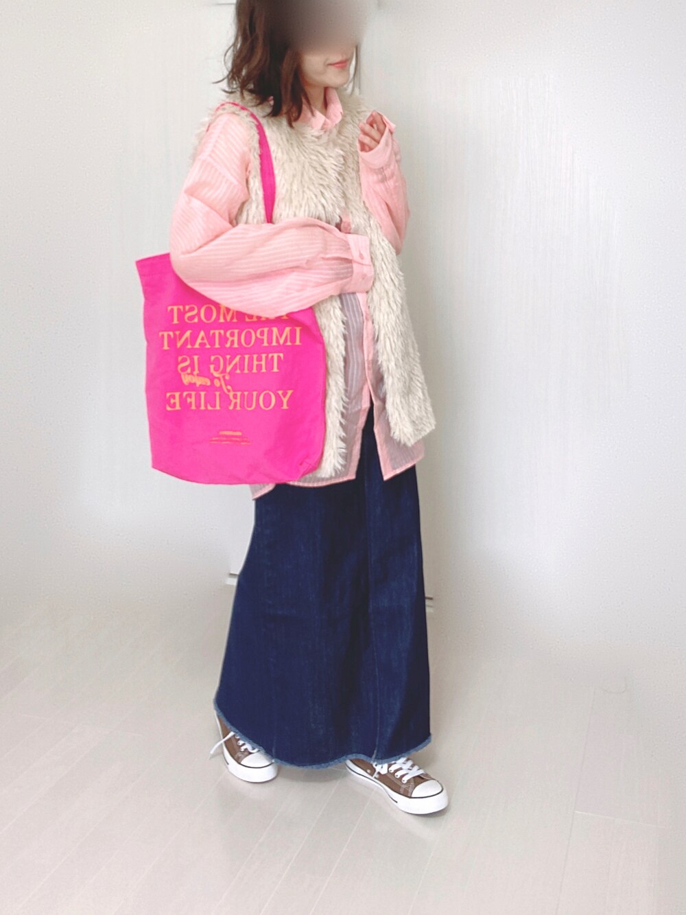 ホワイト系のベスト、ピンク系のシャツ/ブラウス、ブルー系のデニムスカートを着用したレディースの秋コーディネートの2枚目の写真