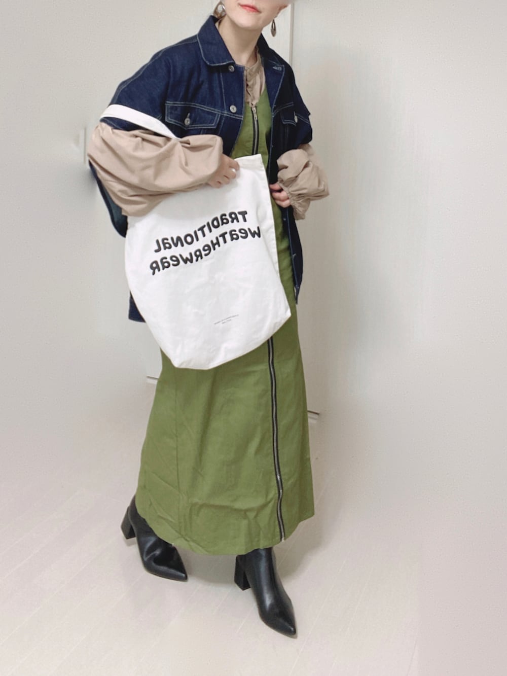 グリーン系のジャンパースカート、ブルー系のベスト、ベージュ系のシャツ/ブラウスを着用したレディースの秋コーディネートの3枚目の写真