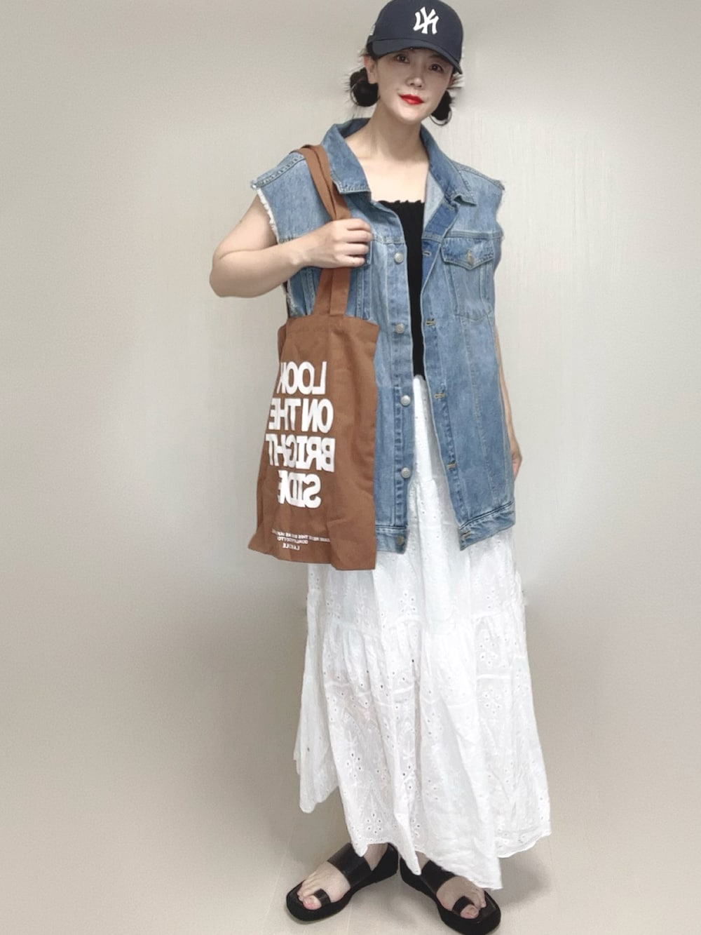 ブラック系のキャミソール、ブラウン系のトートバッグ、ブラック系のサンダルを着用したレディースの夏コーディネートの3枚目の写真