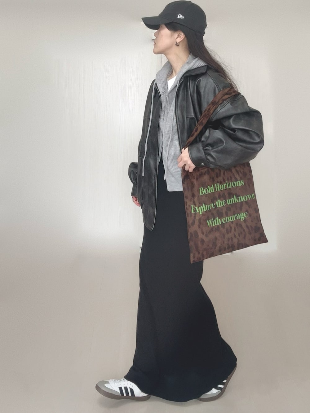 グレー系のパーカー、ブラック系のブルゾン、ブラウン系のトートバッグを着用したレディースの冬コーディネートの2枚目の写真