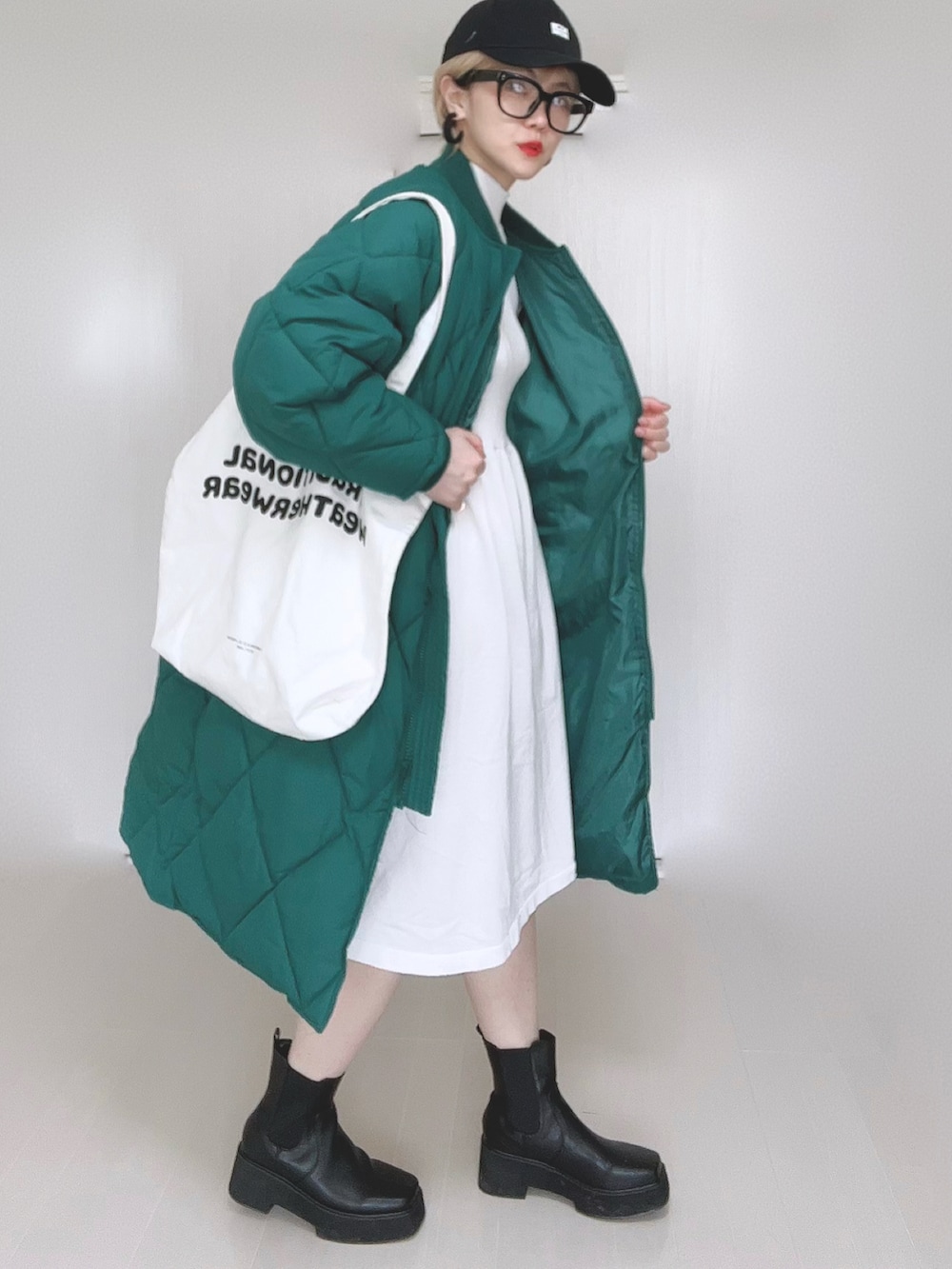 グリーン系のダウンジャケット/コート、ホワイト系のワンピース、ホワイト系のトートバッグを着用したレディースの冬コーディネートの5枚目の写真