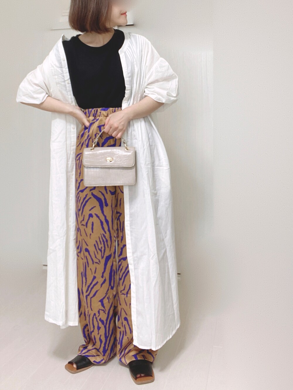 ホワイト系のシャツワンピース、オレンジ系のその他パンツ、ベージュ系のショルダーバッグを着用したレディースの夏コーディネートの5枚目の写真