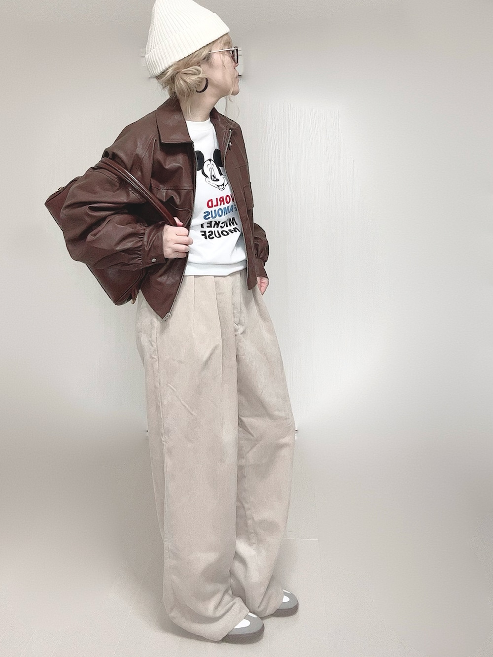 ブラウン系のブルゾン、ブラウン系のショルダーバッグ、ベージュ系のスラックスを着用したレディースの冬コーディネートの4枚目の写真