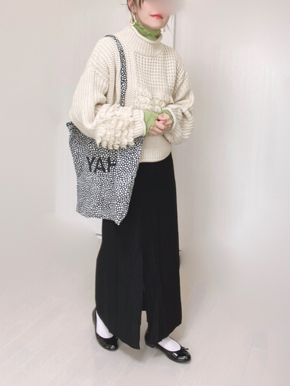 ホワイト系のニット/セーター、ブラック系のスカート、グリーン系のTシャツ/カットソーを着用したレディースの秋コーディネートの3枚目の写真