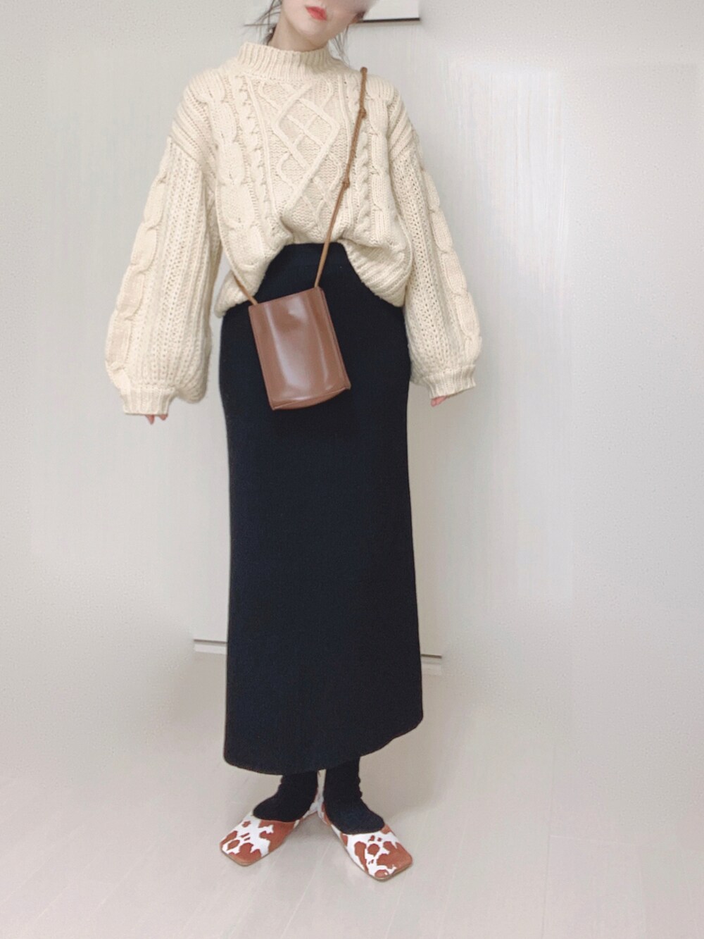 イエロー系のパンプス、ベージュ系のニット/セーター、ブラウン系のショルダーバッグを着用したレディースの秋コーディネートの2枚目の写真