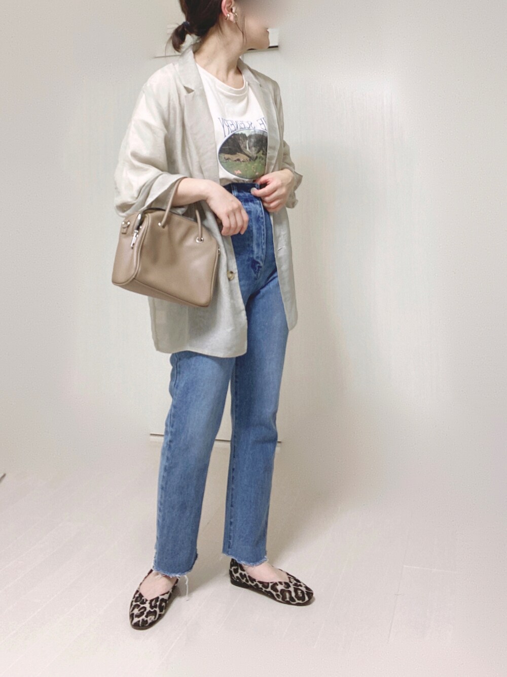 グレー系のテーラードジャケット、ホワイト系のTシャツ/カットソー、ブルー系のデニムパンツを着用したレディースの夏コーディネートの3枚目の写真