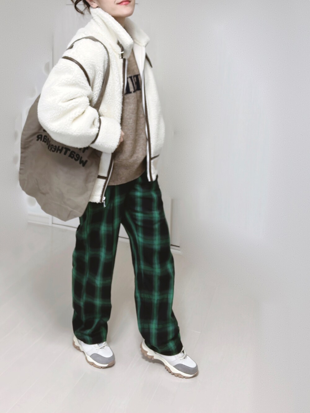 ベージュ系のスニーカー、ホワイト系のブルゾン、ベージュ系のニット/セーターを着用したレディースの冬コーディネートの2枚目の写真