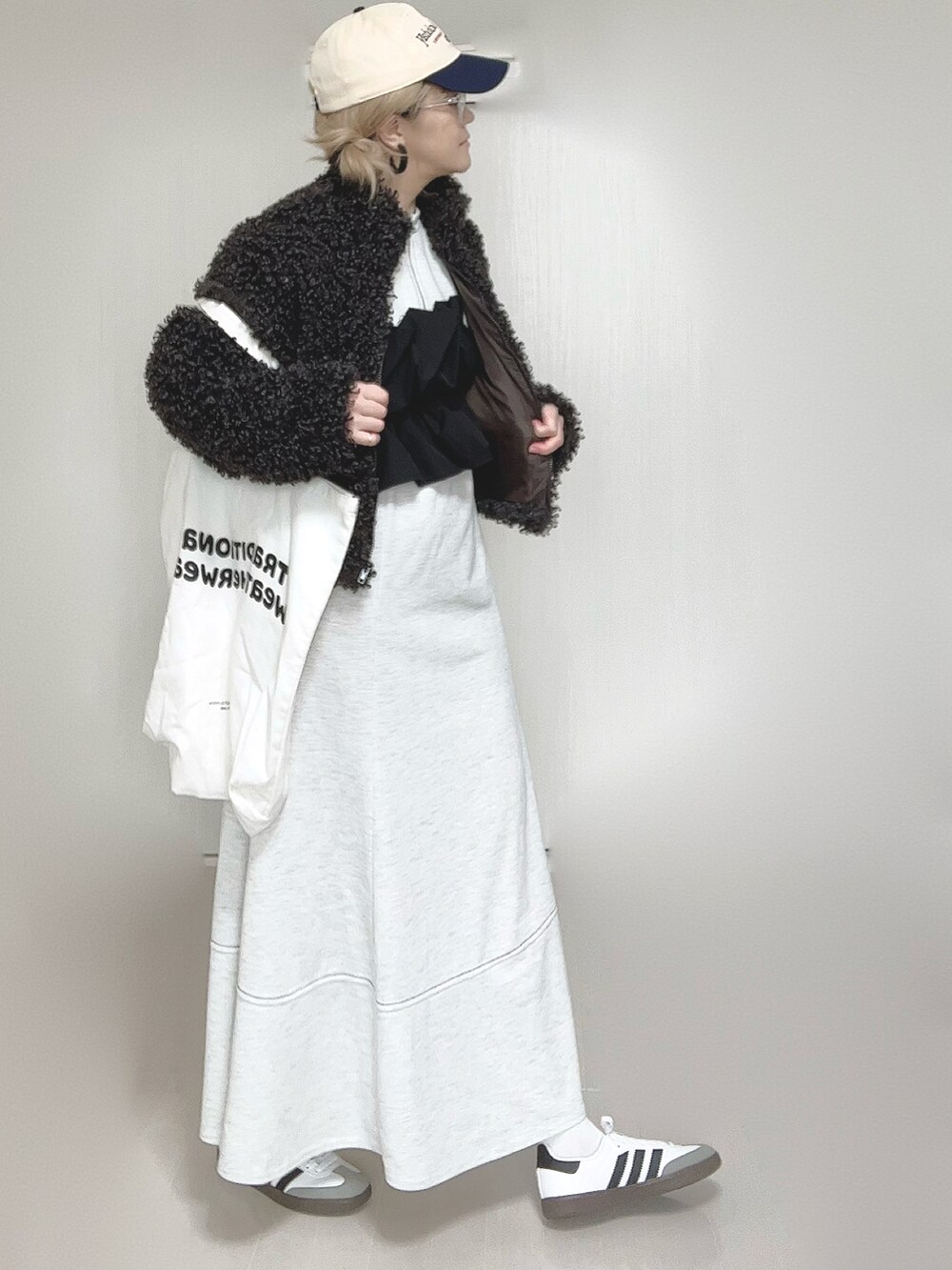 グレー系のブルゾン、グレー系のワンピース、ホワイト系のトートバッグを着用したレディースの秋コーディネートの3枚目の写真