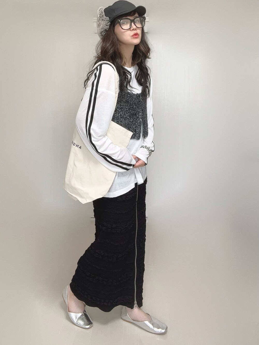 ホワイト系のTシャツ/カットソー、ブラック系のベスト、ブラック系のスカートを着用したレディースの秋コーディネートの2枚目の写真