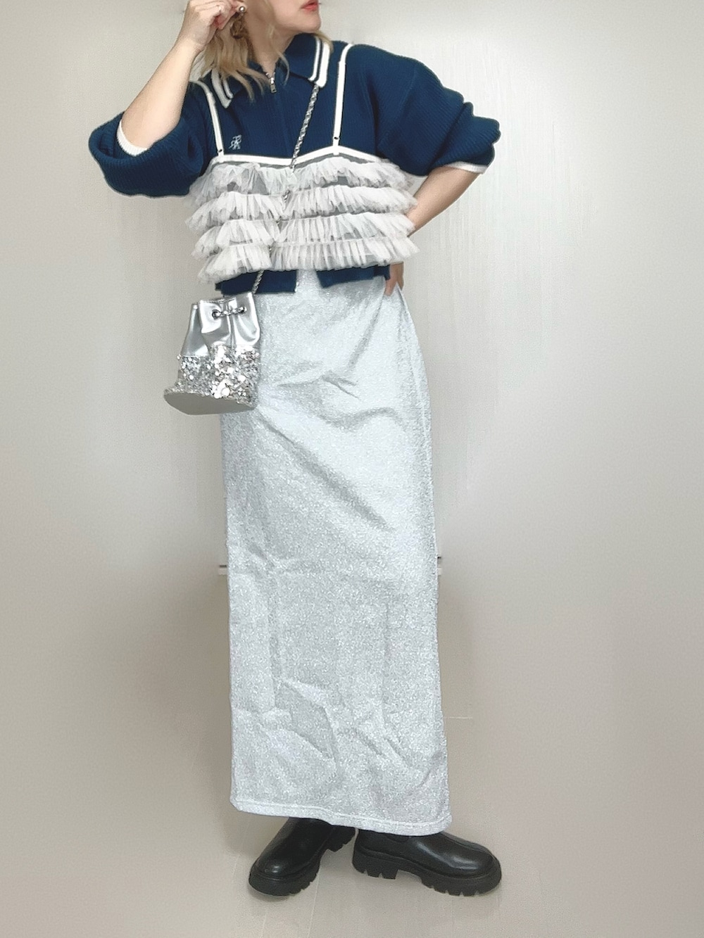 ブルー系のニット/セーター、ブラック系のブーツ、シルバー系のショルダーバッグを着用したレディースの秋コーディネートの2枚目の写真