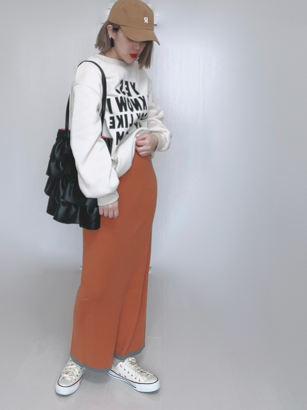 オレンジ系のスカート、ホワイト系のスニーカーを着用したレディースの冬コーディネートの3枚目の写真