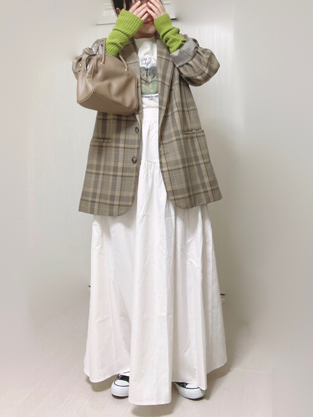 ホワイト系のスカート、ホワイト系のTシャツ/カットソー、ベージュ系のテーラードジャケットを着用したレディースの秋コーディネートの3枚目の写真