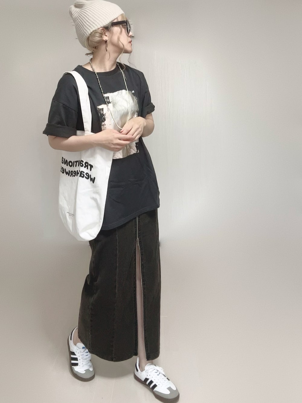 ブラック系のTシャツ/カットソー、ブラック系のスカート、ホワイト系のトートバッグを着用したレディースの夏コーディネートの5枚目の写真