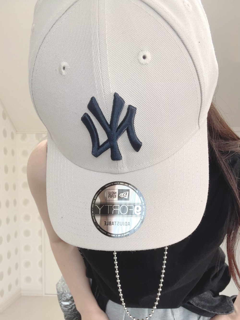 グレー系のスウェットパンツ、シルバー系のトートバッグ、ホワイト系のスニーカーを着用したレディースの夏コーディネートの3枚目の写真