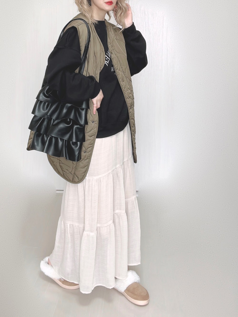 ブラック系のスウェット、ホワイト系のスカートを着用したレディースの秋コーディネートの4枚目の写真