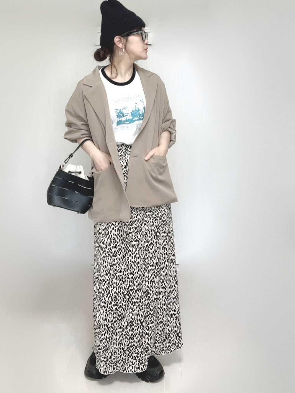 ホワイト系のTシャツ/カットソー、ベージュ系のセットアップ、ブラック系のショルダーバッグを着用したレディースの春コーディネートの2枚目の写真