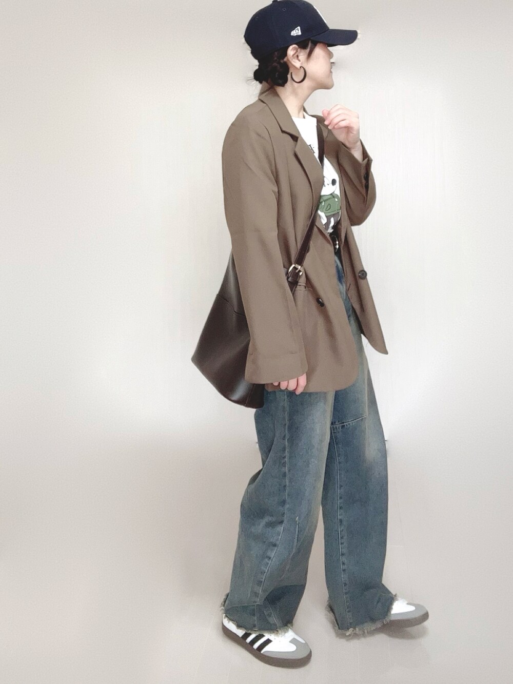 ブラウン系のテーラードジャケット、ホワイト系のTシャツ/カットソー、ブルー系のデニムパンツを着用したレディースの冬コーディネートの4枚目の写真