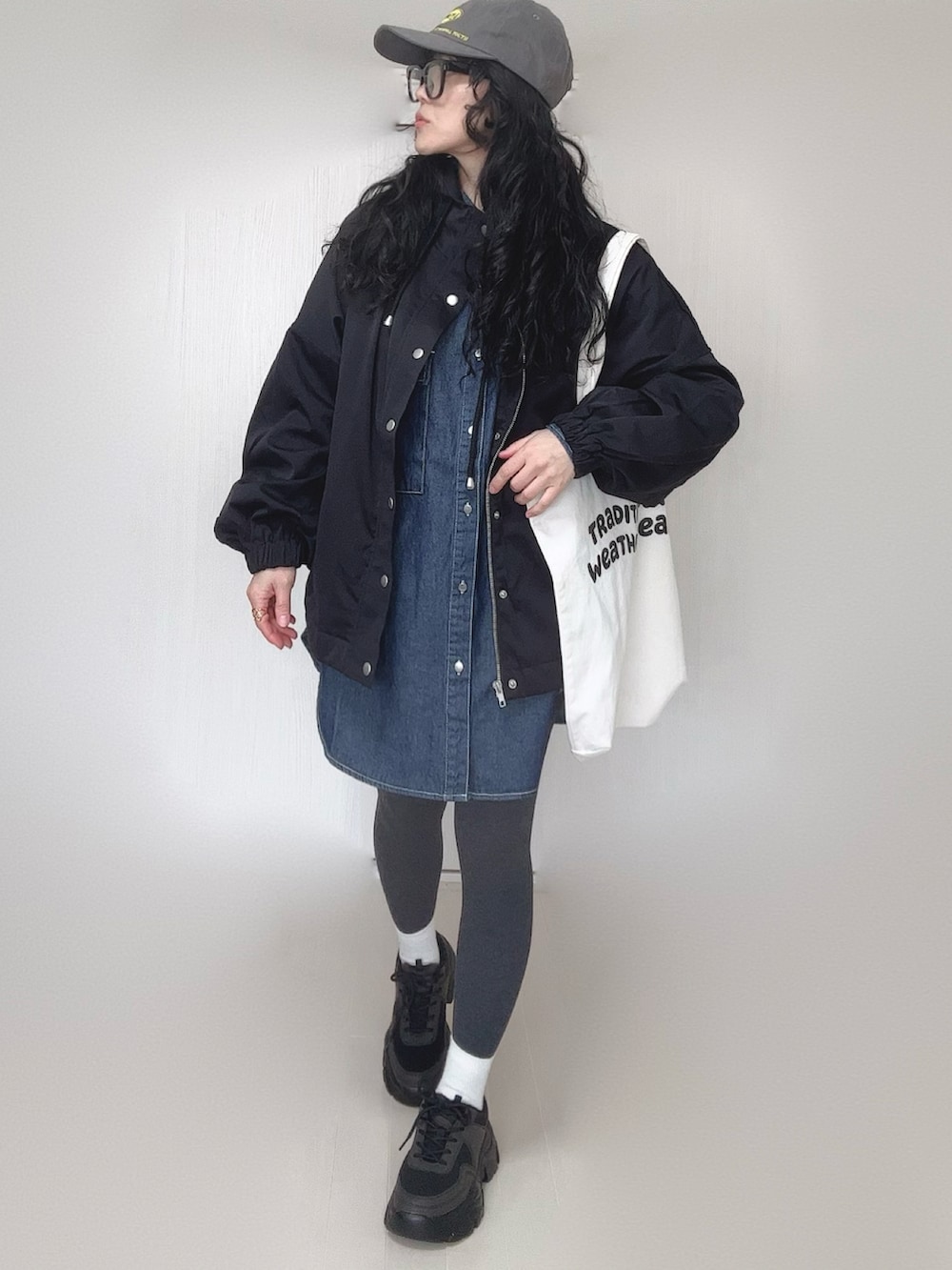 ブルー系のシャツ/ブラウス、ブラック系のマウンテンパーカー、ホワイト系のトートバッグを着用したレディースの春コーディネートの3枚目の写真