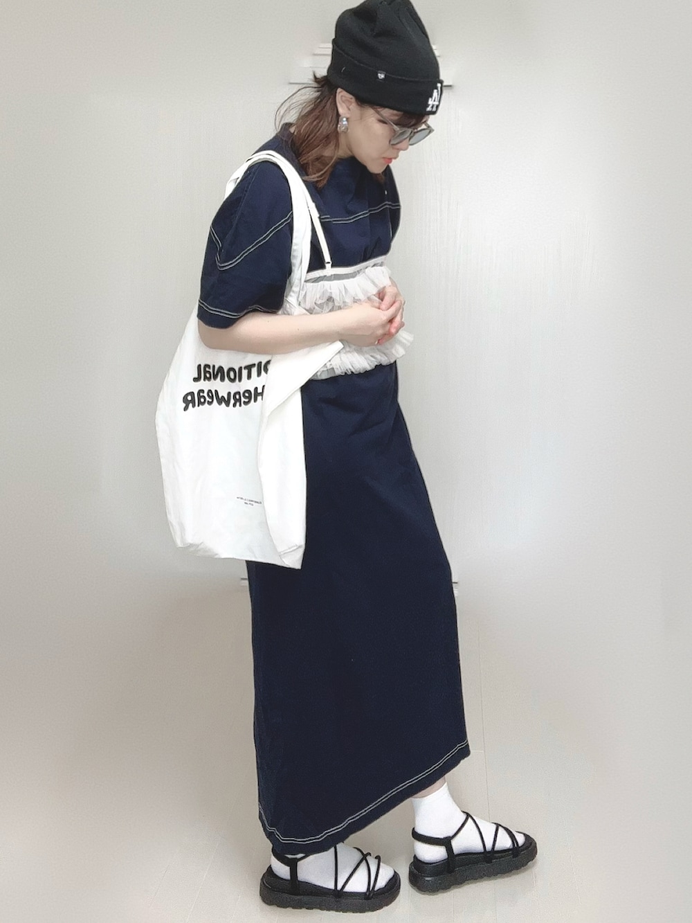 ブルー系のワンピース、ホワイト系のトートバッグ、ブラック系のサンダルを着用したレディースの春コーディネートの3枚目の写真