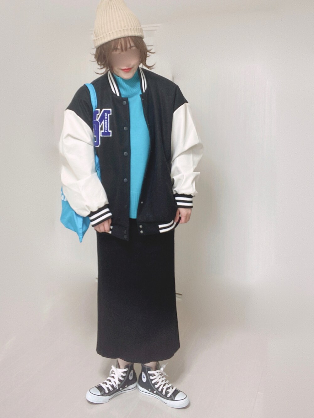 ブルー系のニット/セーター、ブラック系のスタジャン、ブルー系のトートバッグを着用したレディースの冬コーディネートの5枚目の写真