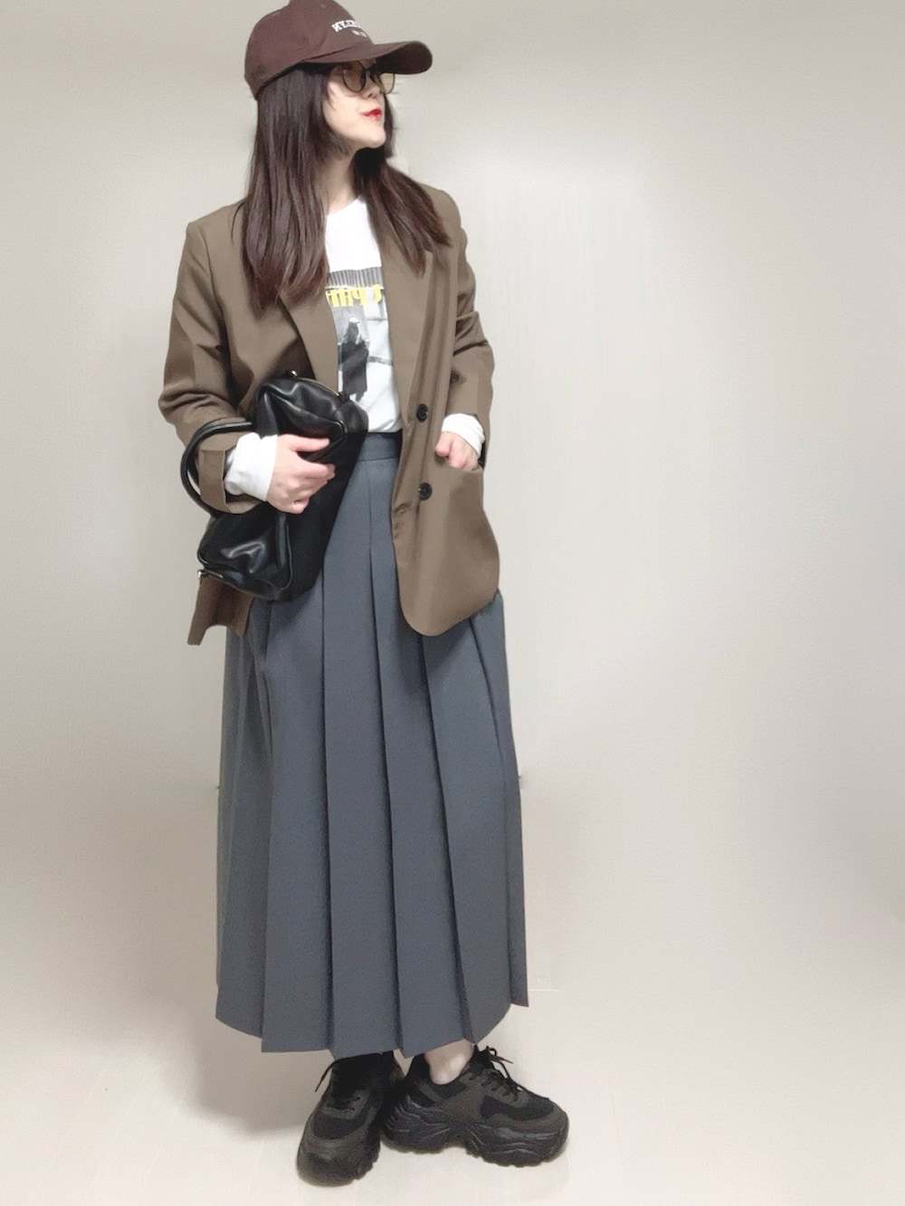 ブラウン系のテーラードジャケット、ホワイト系のTシャツ/カットソー、ブラック系のボストンバッグを着用したレディースの春コーディネートの3枚目の写真