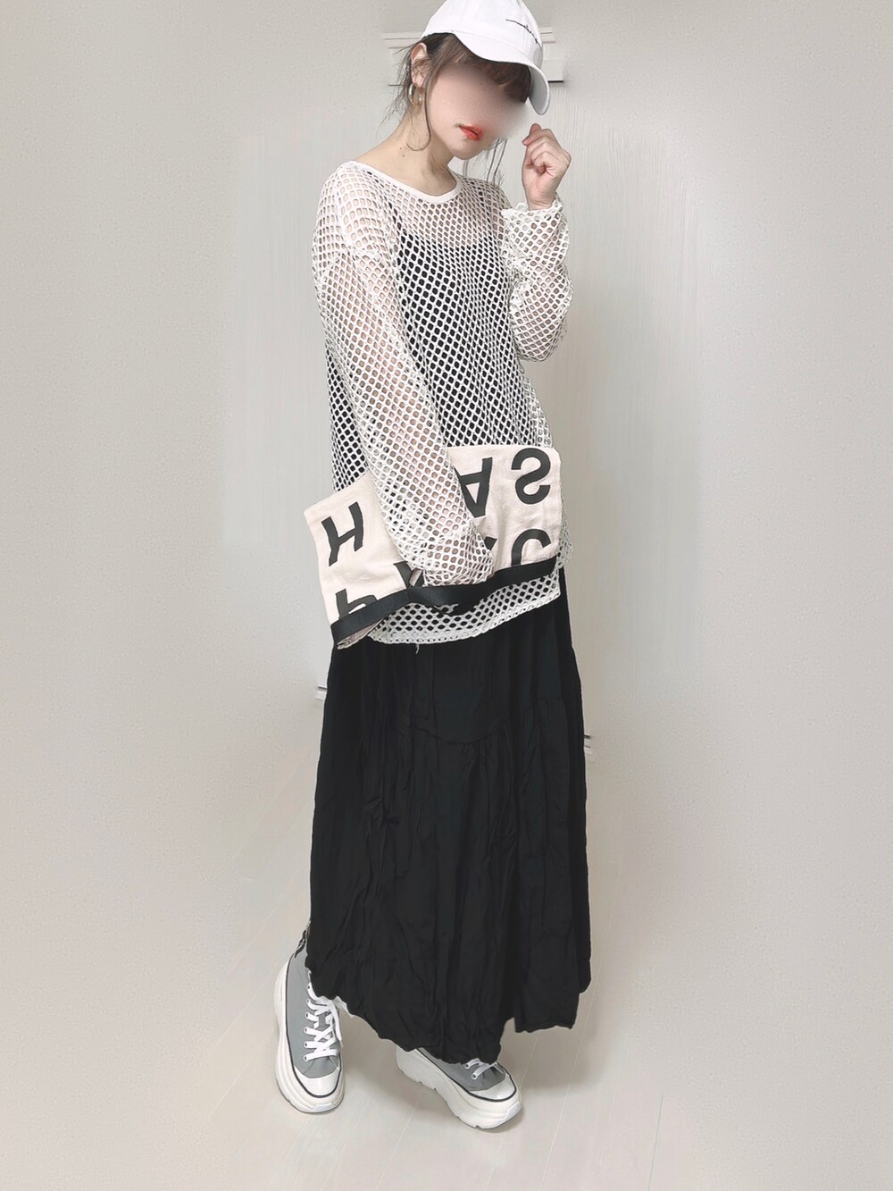 ブラック系のワンピース、ホワイト系のトートバッグ、グレー系のスニーカーを着用したレディースの春コーディネートの3枚目の写真