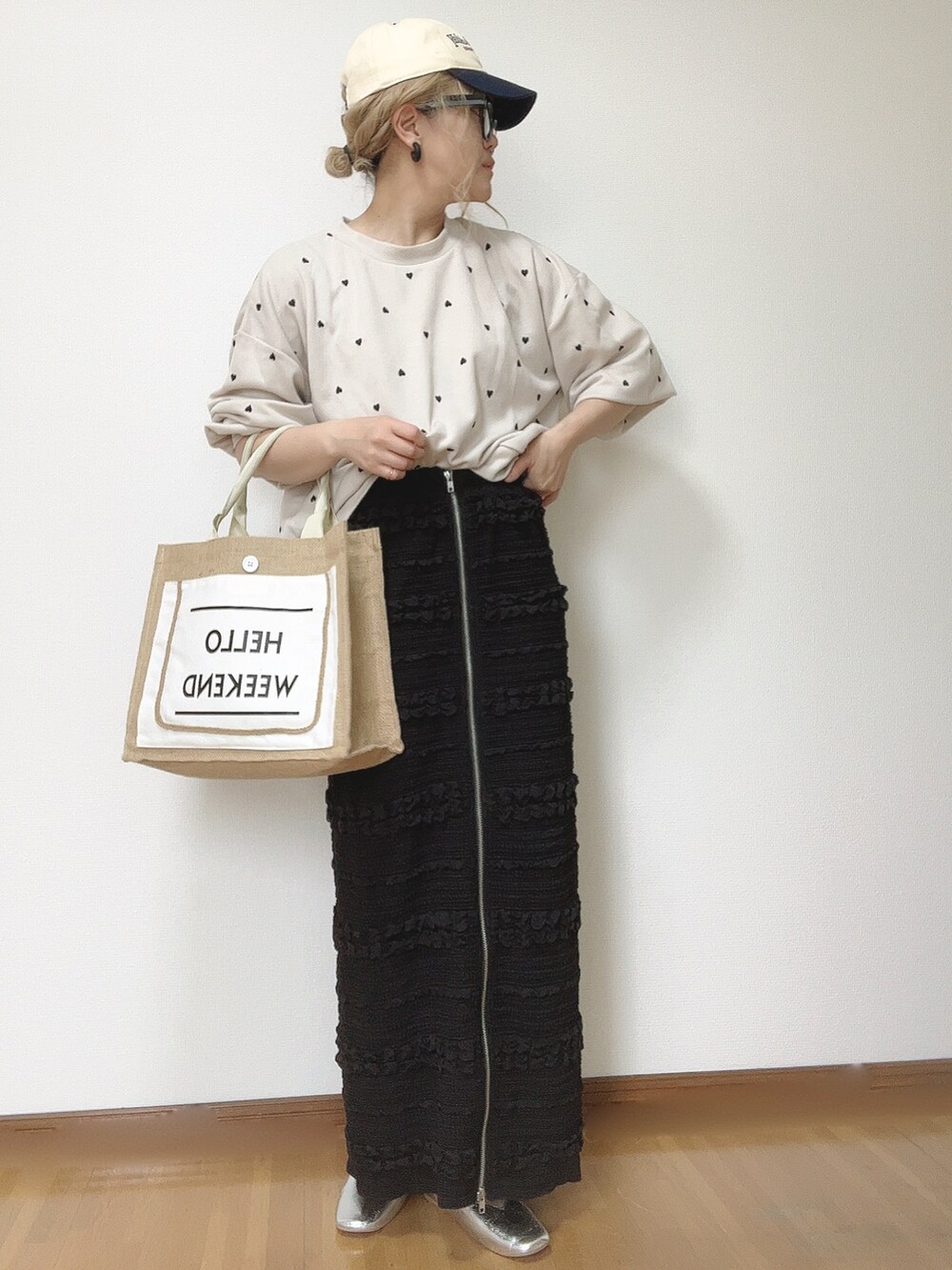 ブラック系のスカート、ホワイト系のかごバッグ、シルバー系のパンプスを着用したレディースの夏コーディネートの5枚目の写真