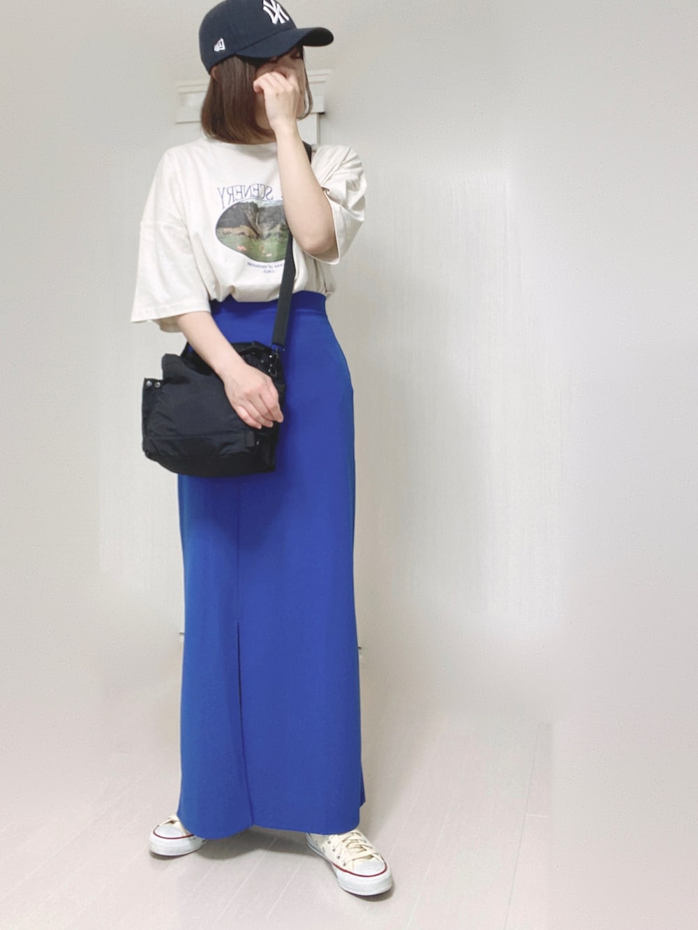 ホワイト系のTシャツ/カットソー、ブラック系のショルダーバッグ、ブルー系のスカートを着用したレディースの夏コーディネートの2枚目の写真