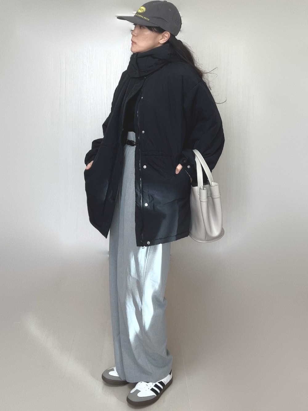 ブラック系のダウンジャケット/コート、グレー系のスラックス、ブラック系のニット/セーターを着用したレディースの冬コーディネートの2枚目の写真