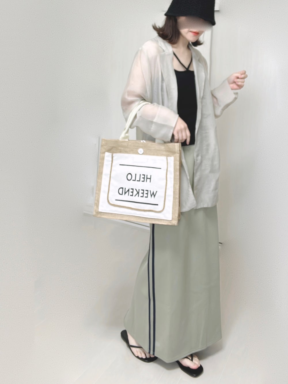 ブルー系のスカート、グレー系のテーラードジャケット、ブラック系のキャミソールを着用したレディースの夏コーディネートの5枚目の写真