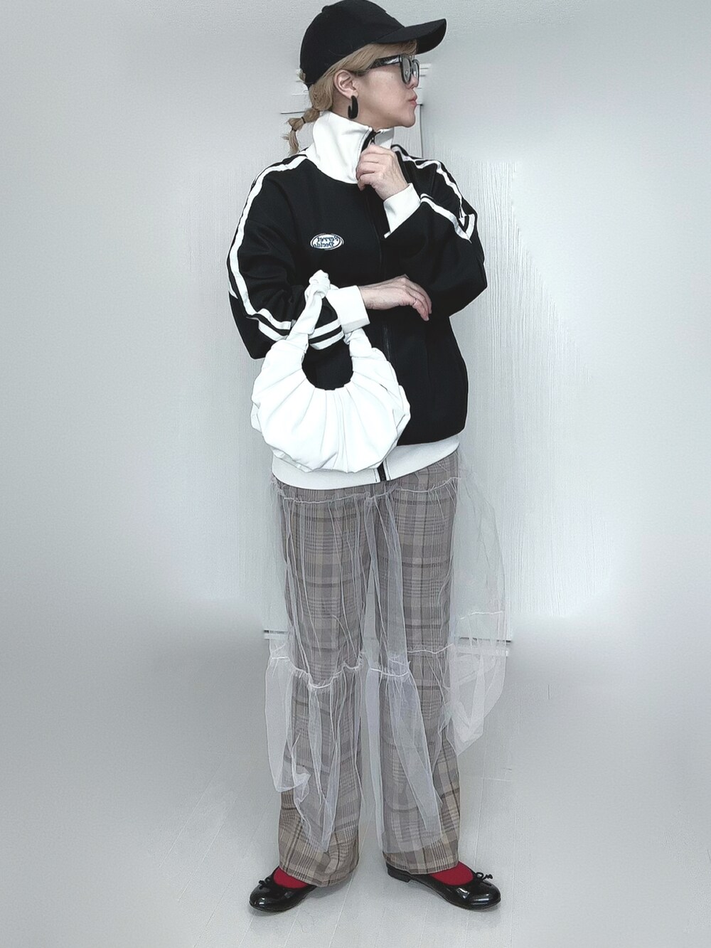 ブラック系のブルゾン、ホワイト系のスカート、ベージュ系のその他パンツを着用したレディースの春コーディネートの2枚目の写真