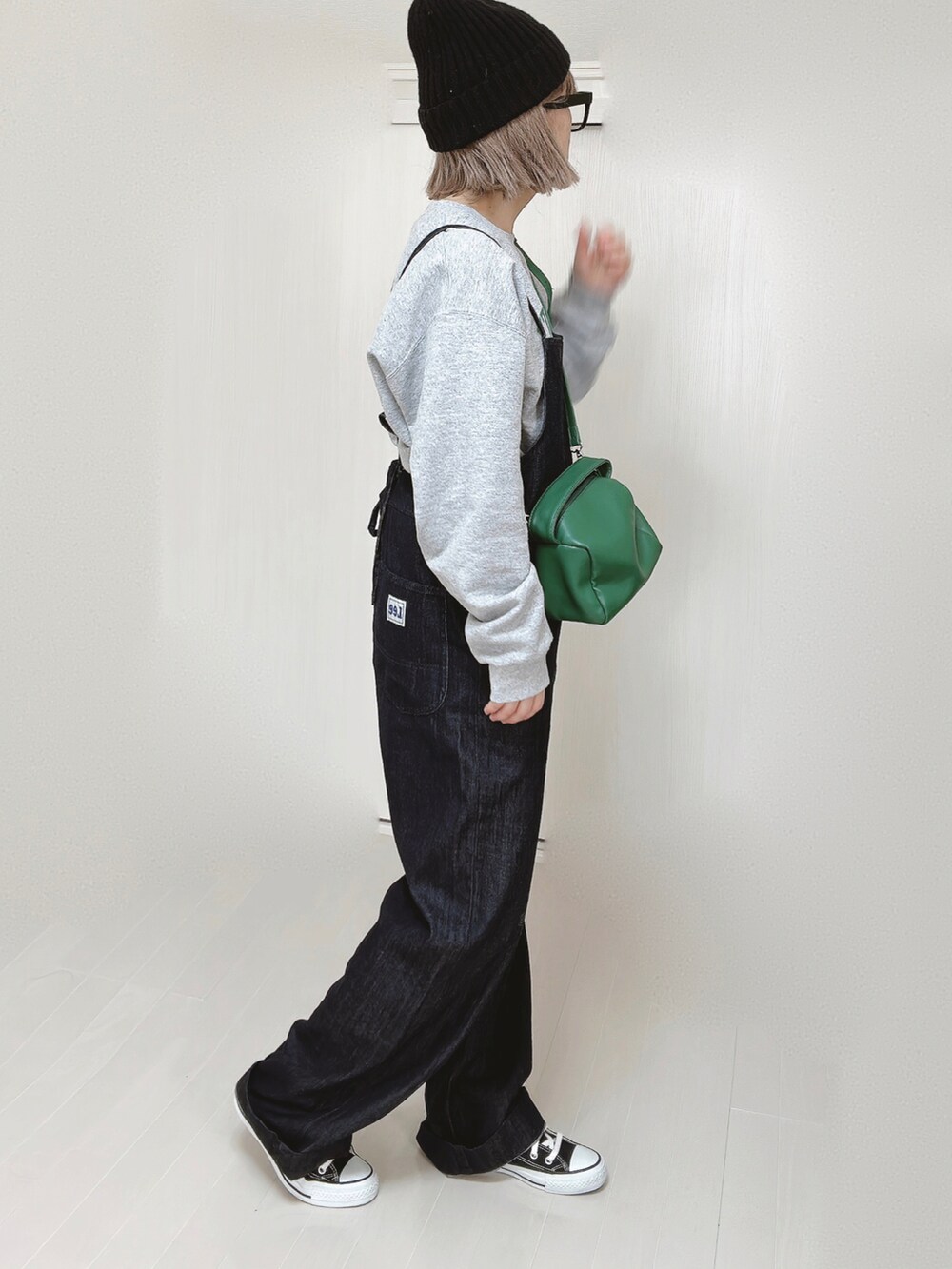 ブルー系のサロペット/オーバーオール、グレー系のスウェット、グリーン系のハンドバッグを着用したレディースの春コーディネートの2枚目の写真