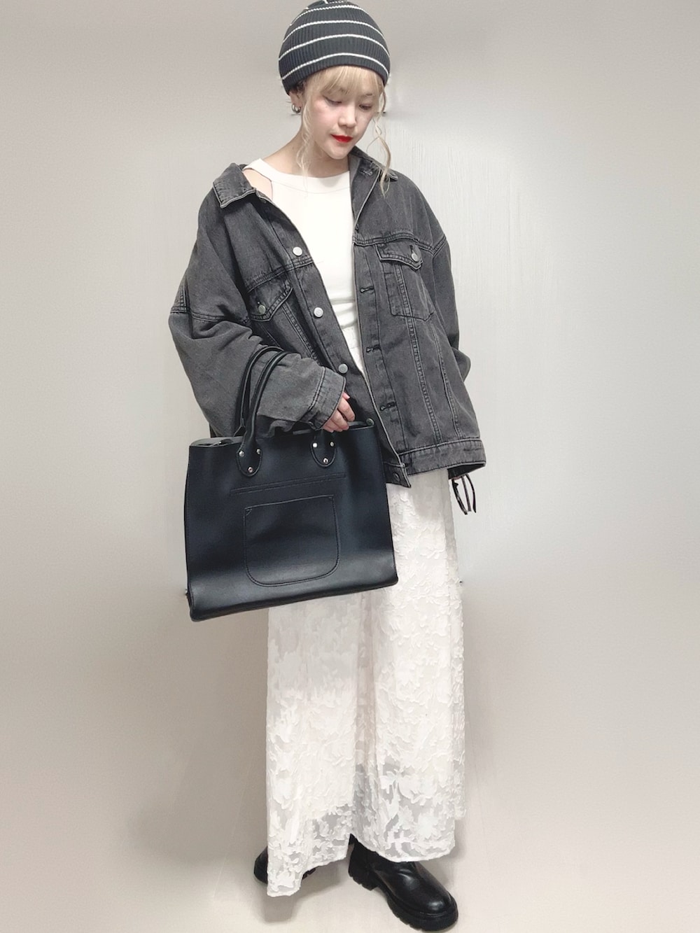 ホワイト系のタンクトップ、ブラック系のデニムジャケット、ブラック系のトートバッグを着用したレディースの秋コーディネートの5枚目の写真