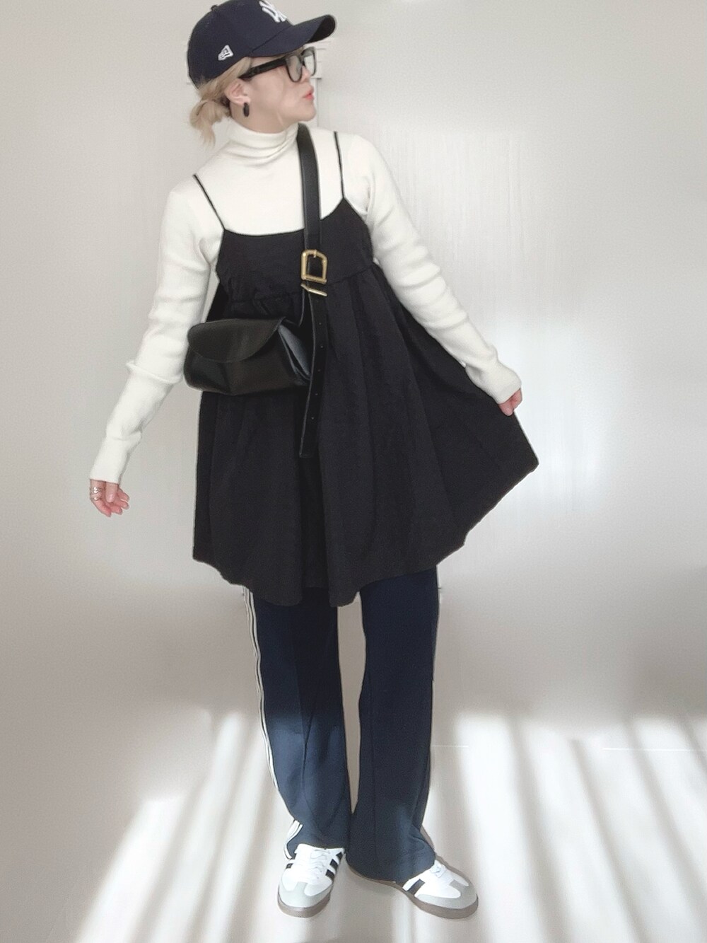 ブルー系のスウェットパンツ、ホワイト系のニット/セーター、ブラック系のワンピースを着用したレディースの春コーディネートの4枚目の写真
