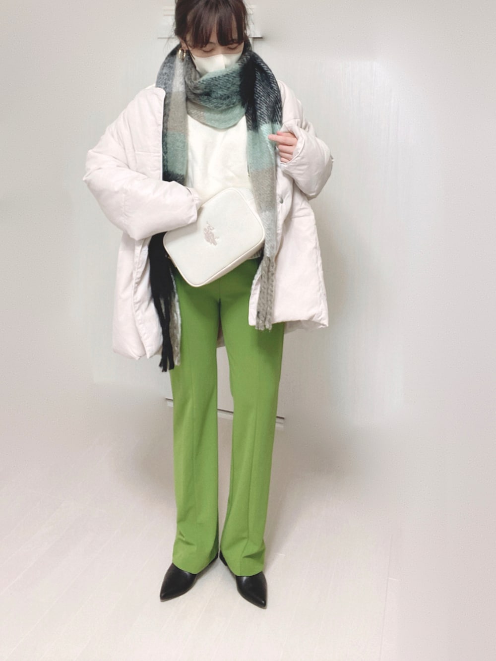 ホワイト系のショルダーバッグ、ホワイト系のダウンジャケット/コート、ホワイト系のニット/セーターを着用したレディースの冬コーディネートの2枚目の写真