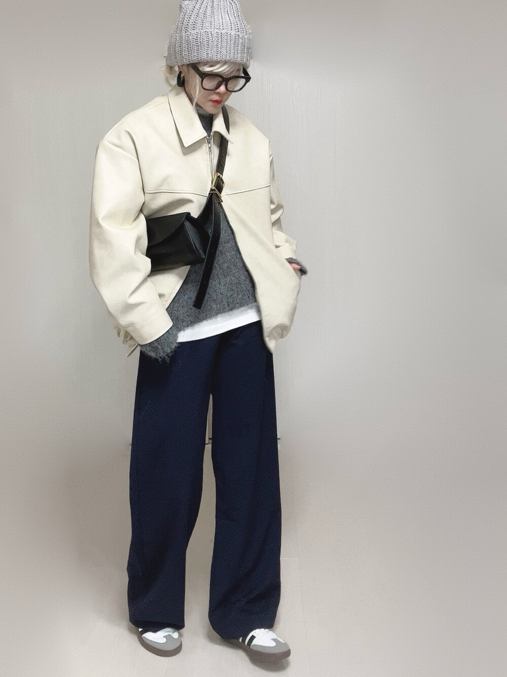 ホワイト系のブルゾン、ホワイト系のTシャツ/カットソー、ブラック系のスラックスを着用したレディースの冬コーディネートの5枚目の写真