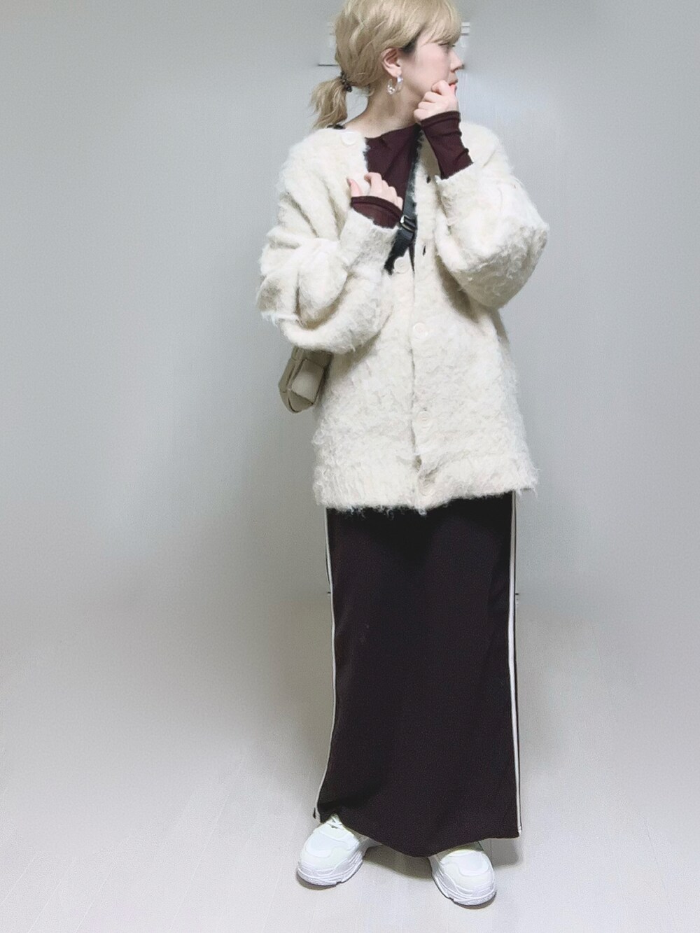 ベージュ系のカーディガン/ボレロ、ブラウン系のTシャツ/カットソー、ホワイト系のスニーカーを着用したレディースの冬コーディネートの4枚目の写真