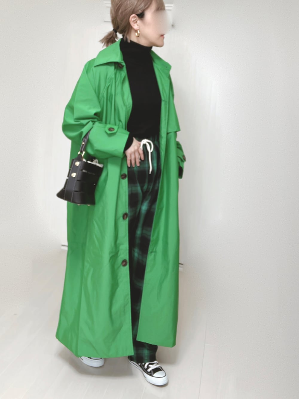 グリーン系のトレンチコート、グリーン系のその他パンツ、ブラック系のショルダーバッグを着用したレディースの春コーディネートの2枚目の写真