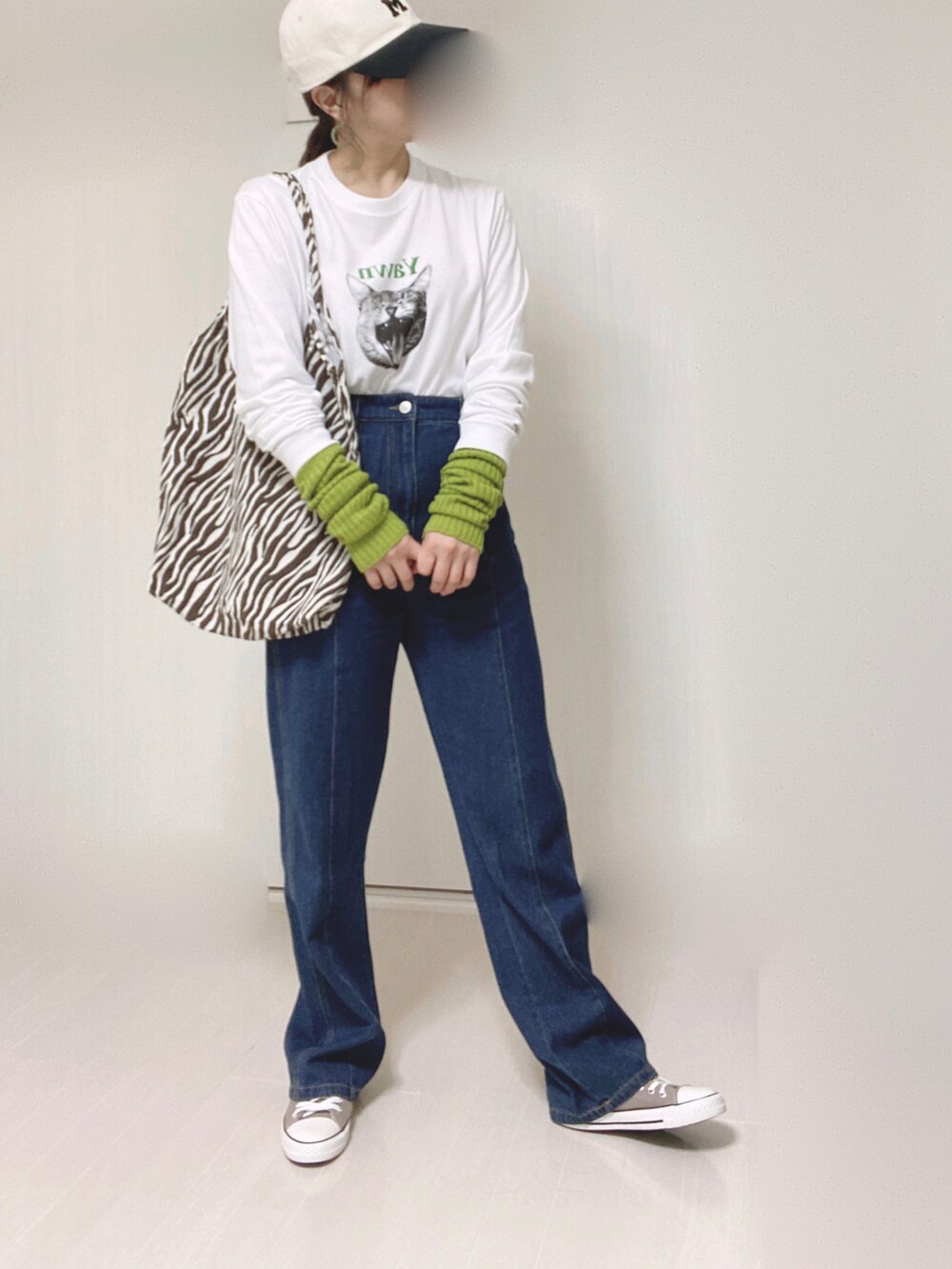 ホワイト系のTシャツ/カットソー、ブルー系のデニムパンツ、グリーン系のアームカバーを着用したレディースの秋コーディネートの3枚目の写真