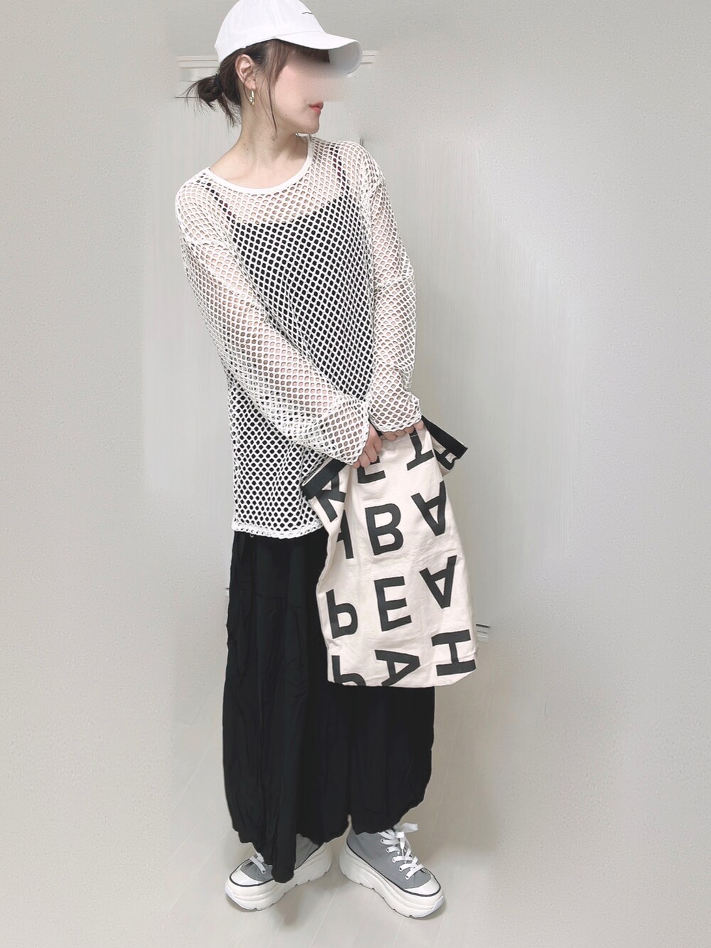 ブラック系のワンピース、ホワイト系のトートバッグ、グレー系のスニーカーを着用したレディースの春コーディネートの5枚目の写真