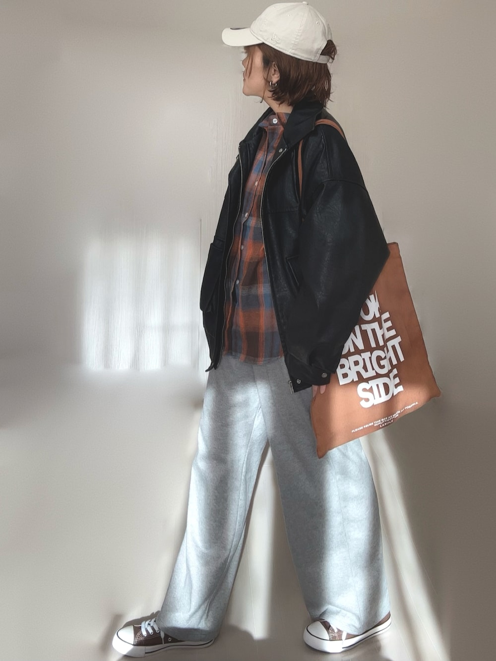 ブラック系のブルゾン、ブラウン系のトートバッグ、ベージュ系のキャップを着用したレディースの冬コーディネートの4枚目の写真