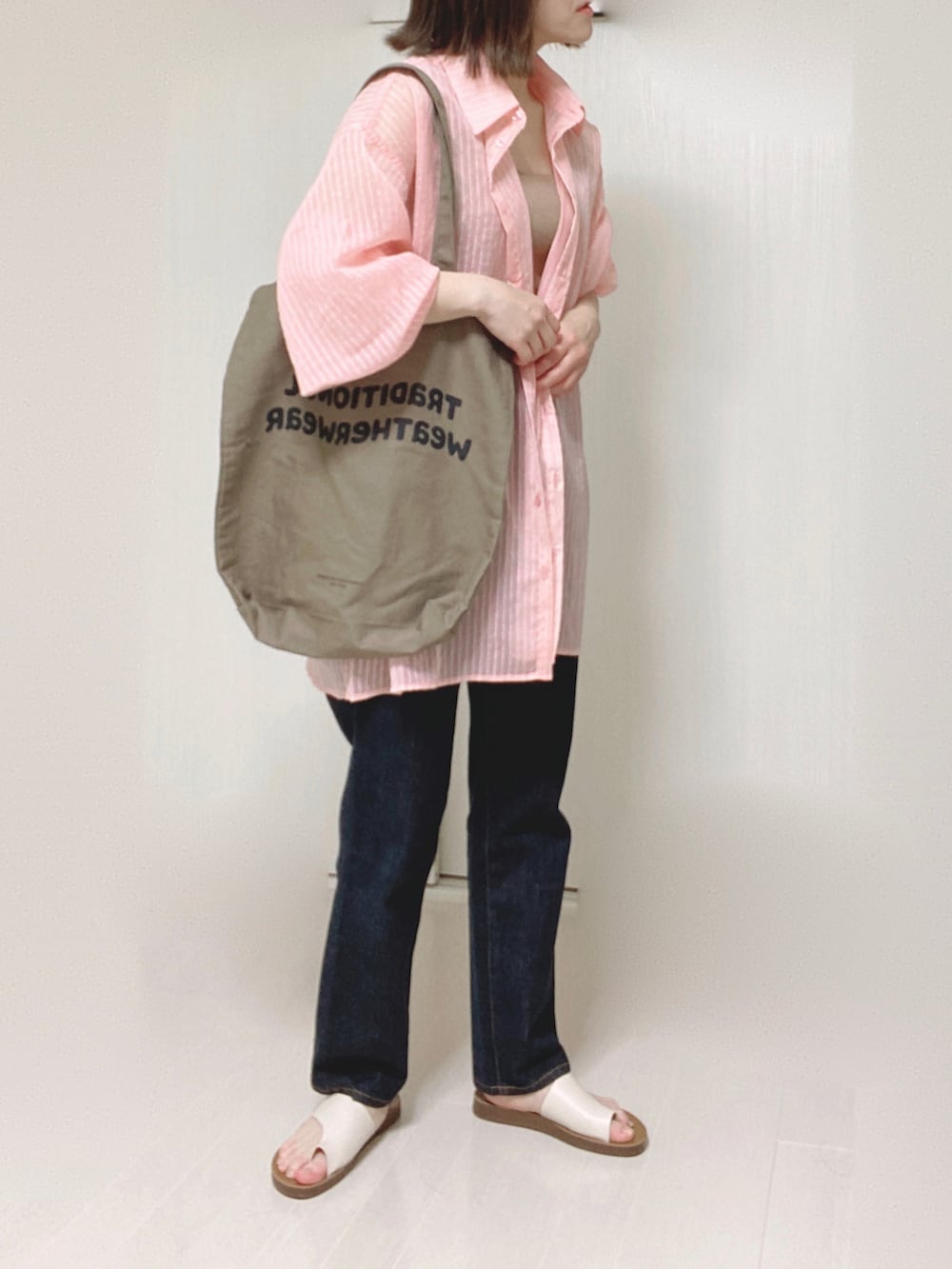 ピンク系のシャツ/ブラウス、ブラウン系のトートバッグ、ブルー系のデニムパンツを着用したレディースの夏コーディネートの4枚目の写真