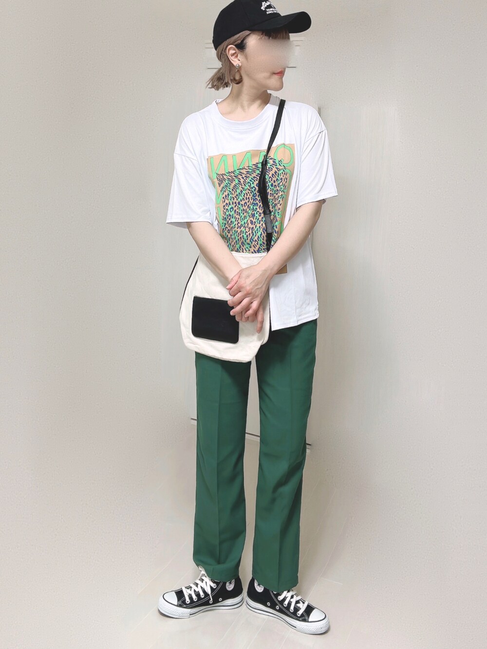 ホワイト系のショルダーバッグ、グリーン系のスラックス、ブラック系のスニーカーを着用したレディースの夏コーディネートの2枚目の写真