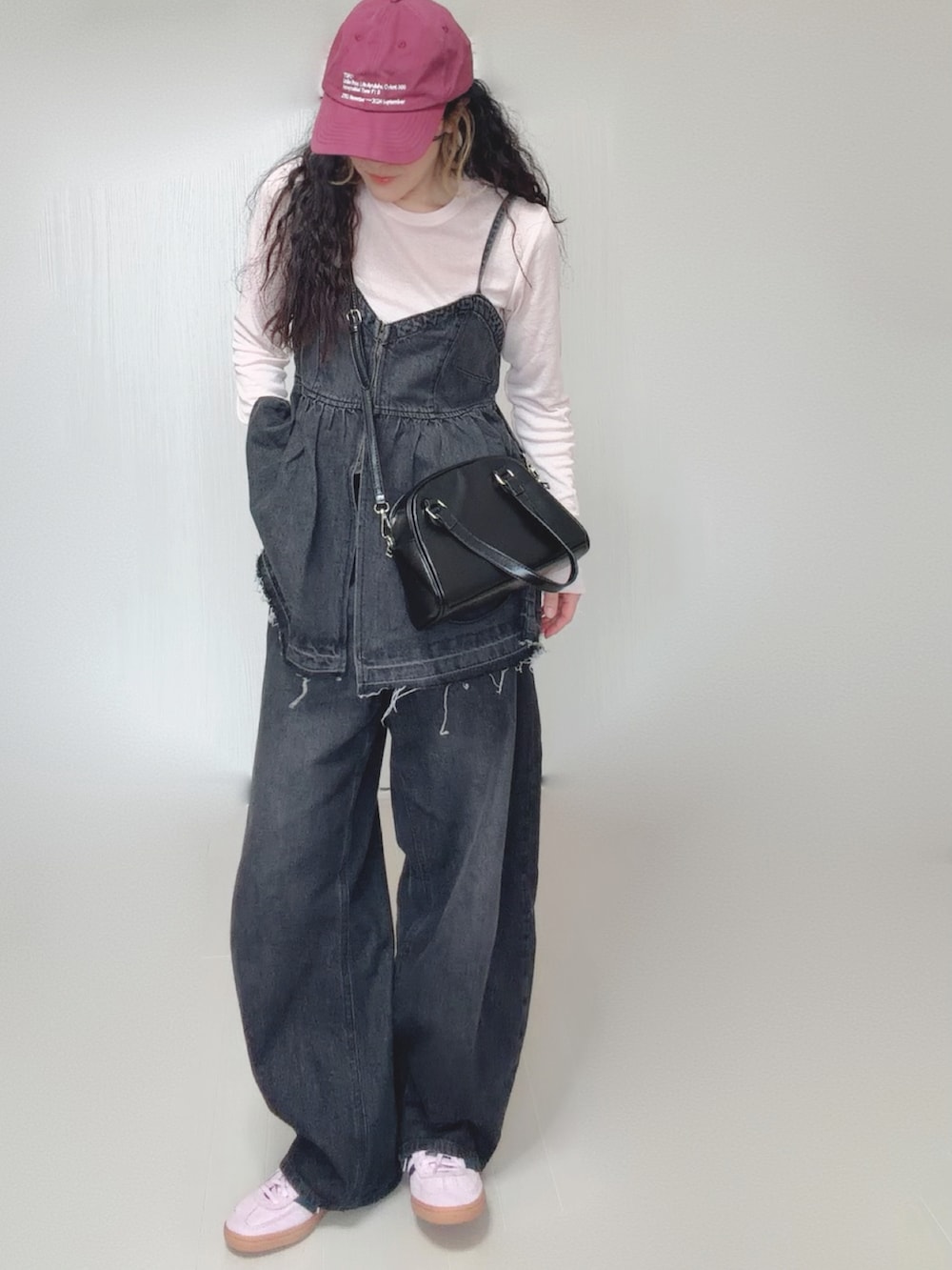 ブラック系のデニムパンツ、ブラック系のボストンバッグ、ピンク系のスニーカーを着用したレディースの春コーディネートの5枚目の写真