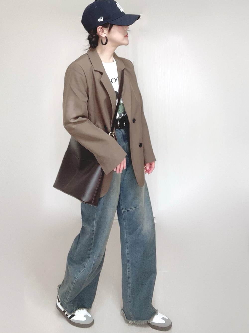 ブラウン系のテーラードジャケット、ホワイト系のTシャツ/カットソー、ブルー系のデニムパンツを着用したレディースの冬コーディネートの2枚目の写真