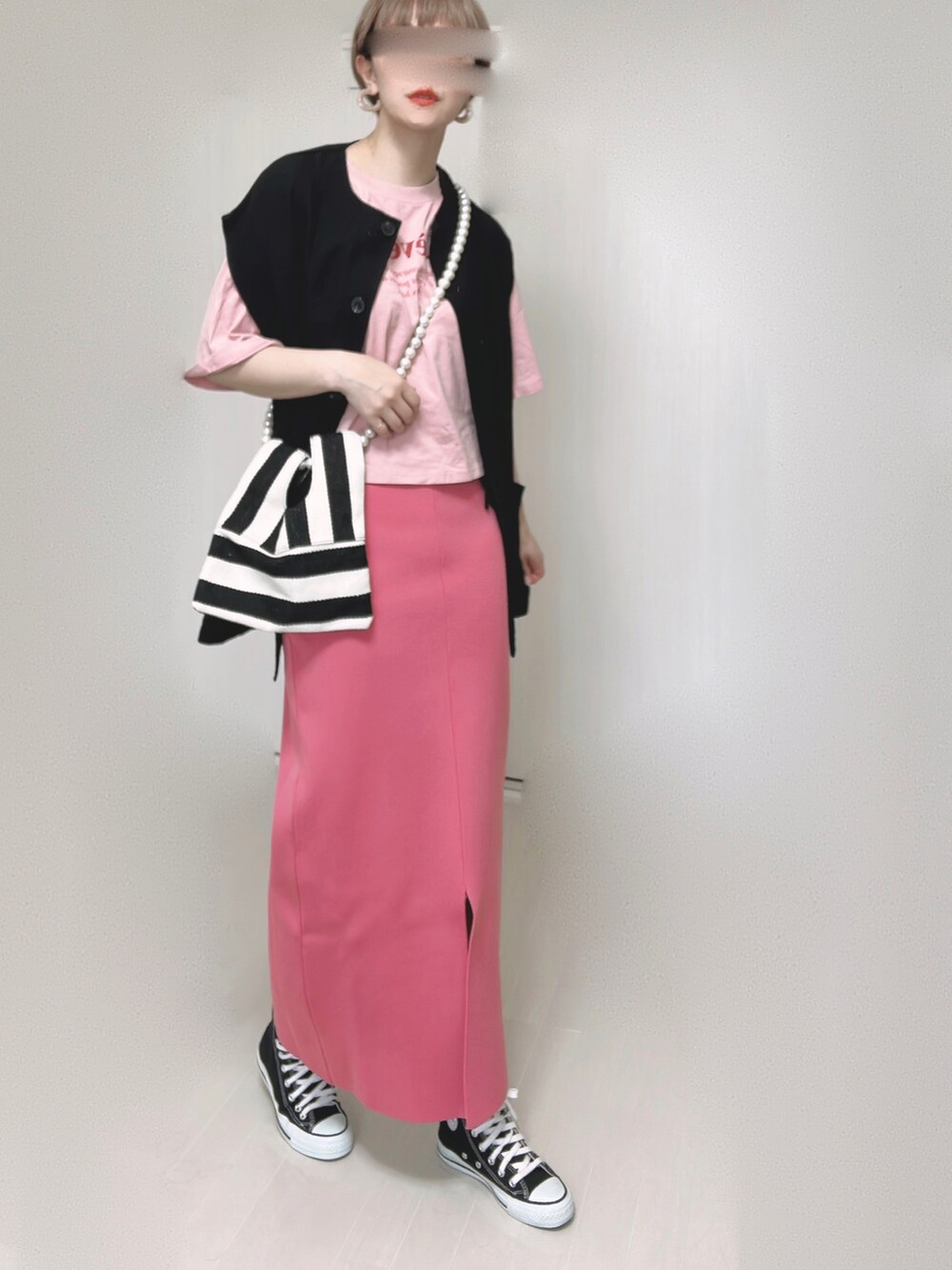 ブラック系のベスト、ホワイト系のショルダーバッグ、ピンク系のスカートを着用したレディースの夏コーディネートの4枚目の写真