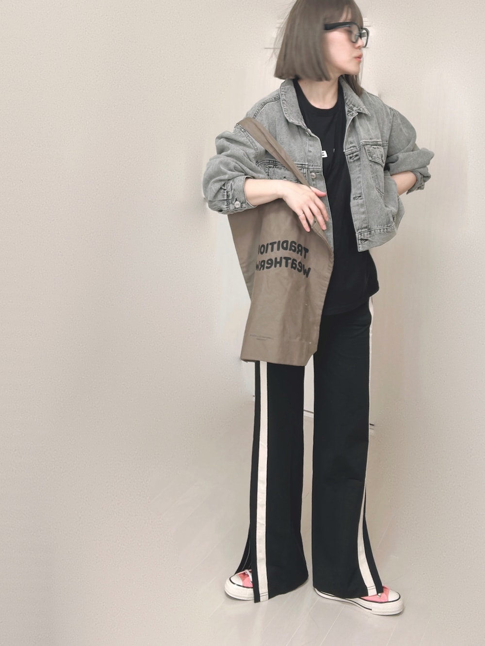 ブラック系のTシャツ/カットソー、ブラック系のデニムジャケット、ブラウン系のトートバッグを着用したレディースの秋コーディネートの2枚目の写真